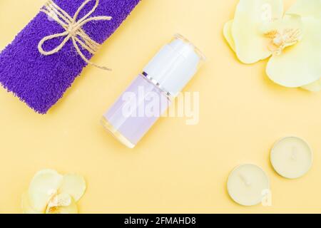 Bougies aromatiques, serviette et lotion sur fond jaune. Vue de dessus, espace de copie. Concept spa, pose plate. Banque D'Images