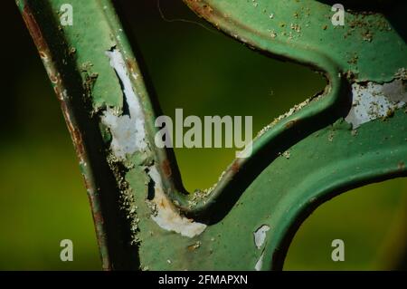 Détails d'un banc rouillé dans un parc. La peinture s'écaille, elle rouille et le lichen s'affaisse. Merveilleux ! Banque D'Images