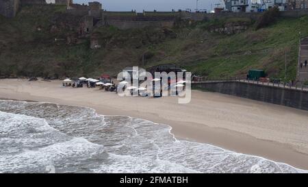 Vue aérienne de Rileys Fish Shack sur King Edwards Bay, Tynemouth. La marée est dedans et il y a des tables sur la plage abritée sous des parasols. Banque D'Images