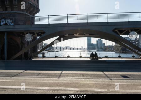 Berlin, Oberbaumbrücke, vue à travers les arcades est jusqu'à la Spree, deux hommes assis, silhouette Banque D'Images