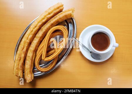 Photo en grand angle de délicieux churros frais et d'une tasse de café Banque D'Images