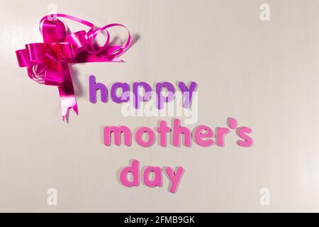 Bonne fête des mères avec ruban rose en forme de noeud sur blanc Banque D'Images