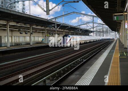 Un train électrique à ็High vitesses passe sur la plate-forme d'une petite gare de Fukushima au Japon. Pendant la journée il n'y a pas de personnes Banque D'Images