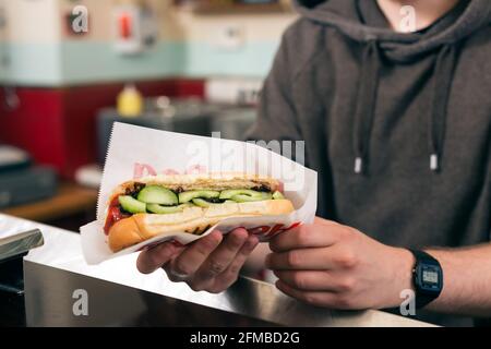 Hotdog - vendeur et client amical dans un fast food snack-bar Banque D'Images