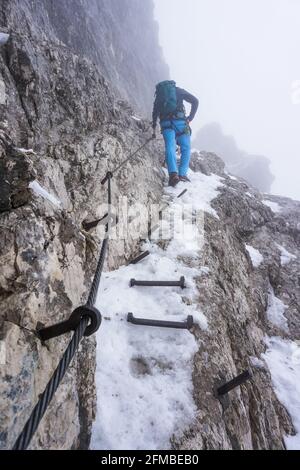 Un randonneur dans la neige sur le chemin du Alpspitze sur l'Alpspitz-Ferrata via ferrata en Bavière Banque D'Images