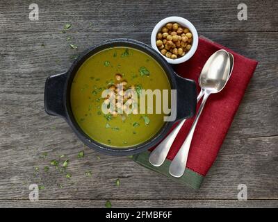 Cuisine ayurvédique - soupe de feuilles de chou-rave dans une casserole noire en fonte, garnie de pois chiches rôtis Banque D'Images