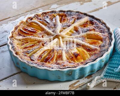 Tarte aux pommes « Alsatian-Art » cuite dans une tarte bleu clair forme avec porte-pots à crochetées bleu clair et blanc Banque D'Images