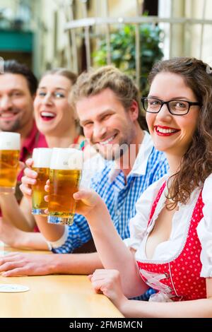 Amis de Tracht bavaroise traditionnelle dans un restaurant ou un pub avec de la bière en Bavière, Allemagne Banque D'Images