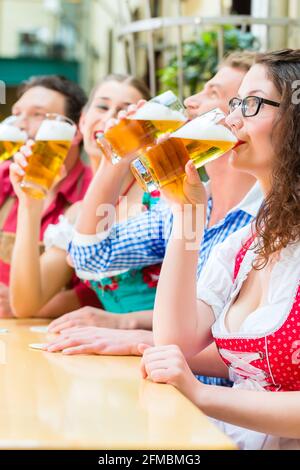 Amis de Tracht bavaroise traditionnelle dans un restaurant ou un pub avec de la bière en Bavière, Allemagne Banque D'Images