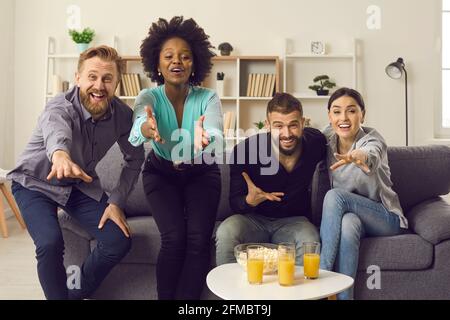 Groupe d'amis regardant un match de football à la télévision, soutenant l'équipe favorite et attendant le but Banque D'Images