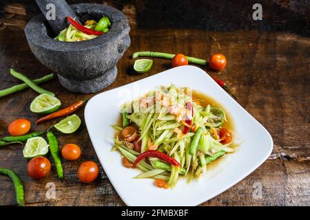 Cuisine thaïlandaise, salade de papaye et salade de papaye dans un plat avec une portion sur une table en bois. Banque D'Images