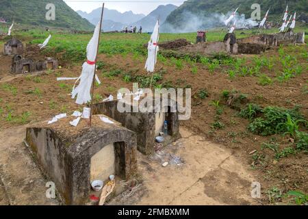 Chaque année, les ancêtres en visite sont des tombes portant des cadeaux et des feux d'éclairage dans les champs de maïs, dans la province de Ha Giang, au nord du Vietnam Banque D'Images