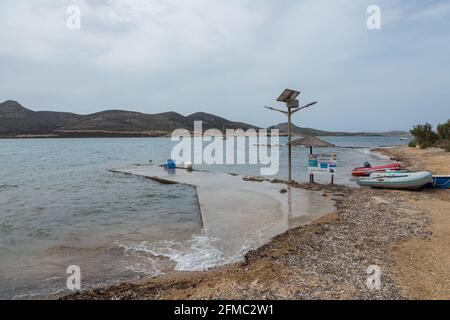 Île d'Antiparos, Grèce - 28 septembre 2020 : vue sur la petite jetée en béton à côté d'une plage d'algues sablonneuses. Pontons amarrés au rivage. Banque D'Images