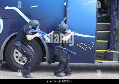 Weimar, Allemagne. 08 mai 2021. Des policiers avec des casques et des mitrailleuses courent le long d'un entraîneur sur un terrain d'entraînement lors d'un exercice de contrôle des catastrophes. Outre les policiers, le service de secours et le service des incendies, l'ensemble du peloton médical et de soutien de la ville de Weimar a été déployé. L'exercice était basé sur une situation d'amak dans un entraîneur. Credit: Bodo Schackow/dpa-Zentralbild/ZB/dpa/Alay Live News Banque D'Images