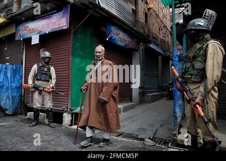 Srinagar, Inde. 07e mai 2021. 7 mai 2021 : un cachemiri marche alors que les troupes indiennes se tiennent à l'extérieur de la grande mosquée du Cachemire pendant le confinement de Covid-19 le dernier vendredi du Ramadan à Srinagar, dans le Cachemire administré par l'Inde, le 07 mai 2021. Des milliers de personnes assistent aux prières les jours normaux chaque année en raison de Covid-19 toutes les mosquées principales ont été fermées. Crédit : ZUMA Press, Inc./Alay Live News Banque D'Images