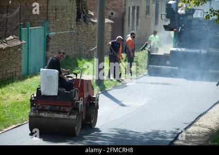 Mihaltsi, Bulgarie - Mai 7 2021: Machine à rouleaux comprimant l'asphalte derrière le finisseur Banque D'Images