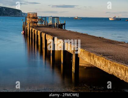 Pots de homard sur une jetée en bois au coucher du soleil à Swanage, Dorset, Royaume-Uni Banque D'Images