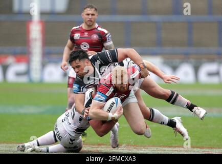 Joe Bullock (au centre) de Wigan Warriors, affronté par Joe Cator (à gauche) du FC Hull lors du quart de finale de la coupe du défi de Betfred au stade Emerald Headingley, à Leeds. Date de la photo: Samedi 8 mai 2021. Banque D'Images