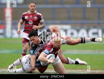 Joe Bullock (au centre) de Wigan Warriors, affronté par Joe Cator (à gauche) du FC Hull lors du quart de finale de la coupe du défi de Betfred au stade Emerald Headingley, à Leeds. Date de la photo: Samedi 8 mai 2021. Banque D'Images