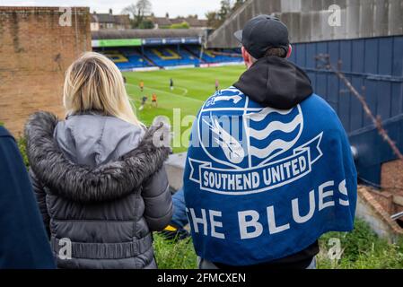 Roots Hall, Southend on Sea, Essex, Royaume-Uni. 8th mai 2021. Une manifestation est en cours au club de football Southend United qui a été relégué à la deuxième Ligue. Les fans accusent le président Ron Martin de se concentrer sur le développement de Roots Hall dans le logement et de se déplacer vers un nouveau stade proposé à Fossetts Farm, aux dépens de l'équipe. Les partisans craignent que Roots Hall ne puisse être développé sans aucune garantie d'une nouvelle maison, risquant ainsi l'avenir du club. Les visiteurs du comté de Newport se disputent un lieu de jeu. Les fans trouvent un point de vue pour regarder le match pendant la COVID 19. Vue vers West Stand Banque D'Images