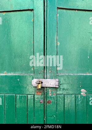 Portes en bois peintes en vert avec fermoir de sécurité, agrafe et cadenas en laiton Banque D'Images