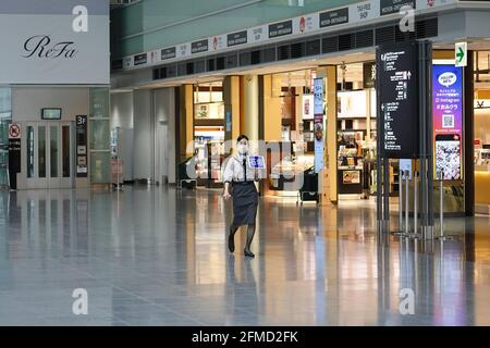 Tokoname, Japon. 08 mai 2021. Le personnel d'une compagnie aérienne portant un masque facial marche dans un terminal vide de l'aéroport international de Chubu Centrair. Le Japon prolonge l'état d'urgence jusqu'à la fin du mois de mai et renforce les mesures de confinement à mesure que le nombre de cas d'infection demeure élevé en période de pandémie du coronavirus. Crédit : SOPA Images Limited/Alamy Live News Banque D'Images