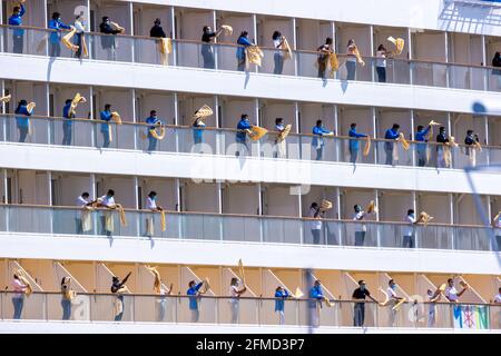 Rostock, Allemagne. 08 mai 2021. Les membres de l'équipage branle les serviettes de bain depuis les balcons du bateau de croisière 'AIDAsol' lorsqu'il entre dans le port. Le navire arrive à Warnemünde à l'occasion de la Conférence maritime nationale du 10.05.2021 et de l'inauguration de la nouvelle centrale électrique côtière. Credit: Jens Büttner/dpa-Zentralbild/dpa/Alay Live News Banque D'Images
