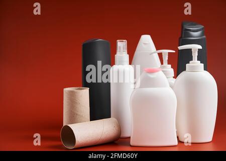 Un ensemble de récipients en plastique propres vides de différentes formes provenant de produits de nettoyage ménagers, de fournitures de douche et de tubes en carton de papier hygiénique. Banque D'Images