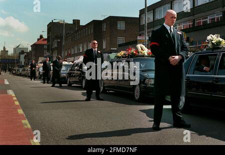 Les gardes de sécurité avril 2000, entourant le cortège funèbre de Charlie Kray, frère aîné des tristement célèbres jumeaux de gangster britannique des années 1960, Ronnie et Reggie Kray, traverse les rues de l'est de Londres avril 19. Reggie Kray a été autorisée à sortir de prison pour assister aux funérailles de son frère qui est décédé alors qu'il purgeait une peine de 12 ans d'emprisonnement pour trafic de drogues Banque D'Images