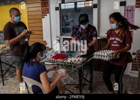 Des bénévoles préparent des dons alimentaires à un garde-manger communautaire dans le quartier de Maginhawa à Quezon City. Malgré les allégations des agents de la loi en tant qu'organisations communistes souterraines qui veulent saper le gouvernement, des pantares communautaires ont germé à travers le pays la semaine dernière pour aider les personnes touchées par des mesures strictes de quarantaine afin de freiner la propagation de la coronavirus. Metro Manille, Philippines. Banque D'Images