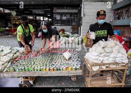 Des bénévoles préparent des dons alimentaires à un garde-manger communautaire dans le quartier de Maginhawa à Quezon City. Malgré les allégations des agents de la loi en tant qu'organisations communistes souterraines qui veulent saper le gouvernement, des pantares communautaires ont germé à travers le pays la semaine dernière pour aider les personnes touchées par des mesures strictes de quarantaine afin de freiner la propagation de la coronavirus. Metro Manille, Philippines. Banque D'Images