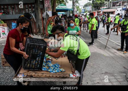 Des bénévoles préparent des dons alimentaires à un garde-manger communautaire dans le quartier de Maginhawa à Quezon City. Malgré les allégations des agents de la loi en tant qu'organisations communistes souterraines qui veulent saper le gouvernement, des pantares communautaires ont germé à travers le pays la semaine dernière pour aider les personnes touchées par des mesures strictes de quarantaine afin de freiner la propagation de la coronavirus. Metro Manille, Philippines. Banque D'Images