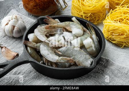 Taglierini aux pâtes avec sauce pesto et ingrédients pour crevettes, sur fond de pierre grise Banque D'Images