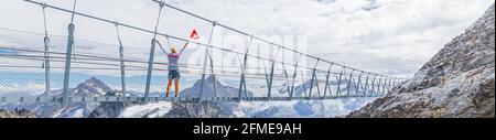 Vue panoramique d'une fille avec drapeau suisse sur le pont suspendu de Titlis Cliff Walk. Sommet du Titlis avec glacier dans les Alpes Uri. Point de vue dans Banque D'Images