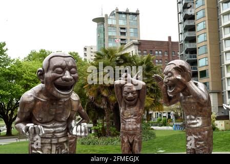 Statues de la sculpture A-Maze-ing rire de l'artiste Yue Minjun se tenir devant les jardins avec des palmiers et avec appartements et condominiums dans Banque D'Images