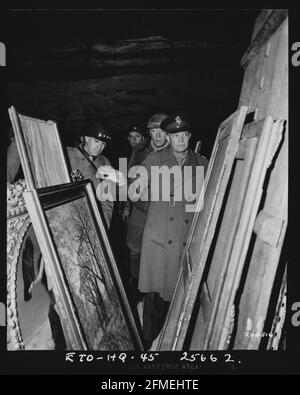 Pendant la Seconde Guerre mondiale, le général Dwight D. Eisenhower inspecte les peintures dans une mine de sel à Merkers, près de Gotha, en Allemagne, où le gouvernement nazi stockait des trésors d'art et de l'or, pillées dans les pays occupés, le 12 avril 1945. Le Commandant suprême des forces alliées était accompagné du général Omar N. Bradley, à gauche, et du Lieutenant général George Patton Jr., immédiatement derrière lui. Plus de 20 pour cent de l'art européen a été pillé par les nazis sous Hitler, et jusqu'à 100,000 œuvres sont encore considérées comme disparues. Banque D'Images