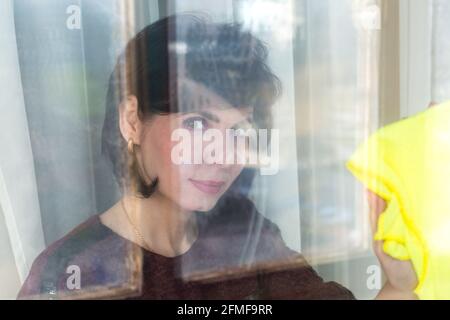 Femme adulte avec des cheveux courts nettoie la maison., Banque D'Images