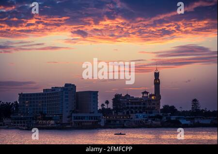 Coucher de soleil sur la ville d'Alexandrie avec silhouettes du Palais Royal et du Parc Montazah sur la mer Méditerranée, Egypte. Banque D'Images