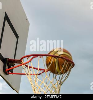 Le basket-ball en passant par hoop Banque D'Images