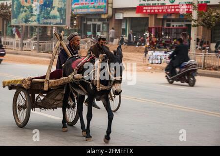 Un vieil homme ride un mulet et panier autour du bazar dimanche à Kashgar, la Province du Xinjiang, Chine Banque D'Images