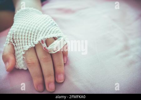 Gros plan d'une solution saline intraveineuse (iv) goutte-à-goutte dans la main du patient d'un enfant avec un espace de copie. Maladie enfant admis à l'hôpital. Histoires sur les soins de santé. Vintage f Banque D'Images