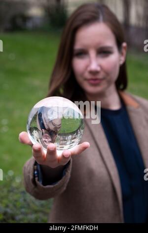 brunette femme tenant une sphère de verre dans sa main Banque D'Images