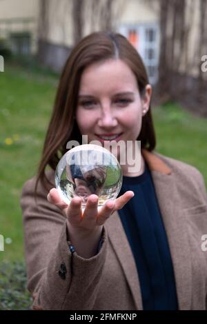 jeune femme brune tenant une sphère de verre dans sa main Banque D'Images