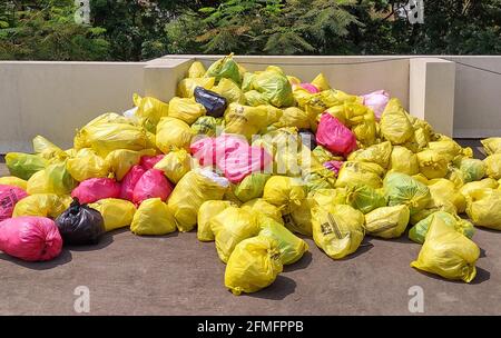 Tas de sacs de déchets médicaux de différentes couleurs contenant utilisé Les EPI sont jetés sur la terrasse d'un hôpital Banque D'Images