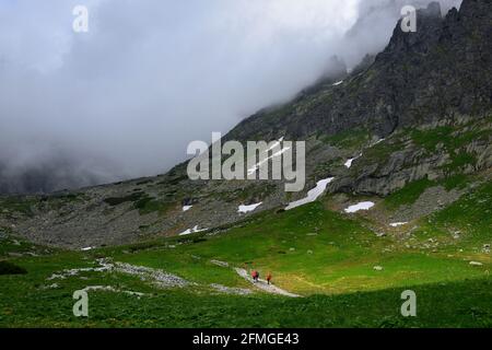 Randonneurs sur un sentier au-dessus du lac Velicke pleso et de la cascade de vodopad Velicky dans les Hautes Tatras. Slovaquie. Banque D'Images