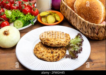 Préparation de hamburgers végétariens avec des patties rondes ou hamburgers à base de céréales, légumes et légumineuses Banque D'Images