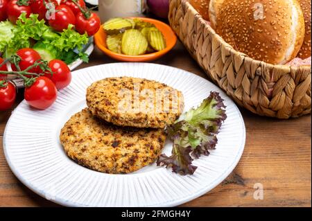 Préparation de hamburgers végétariens avec des patties rondes ou hamburgers à base de céréales, légumes et légumineuses Banque D'Images