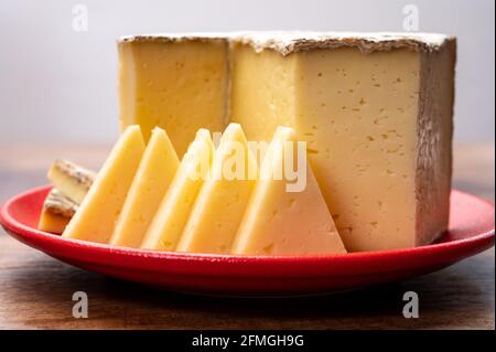 Collection de fromages, tomme de Savoie de Savoie dans les Alpes françaises, fromage de lait de vache doux avec intérieur beige et croûte épaisse gris brunâtre Banque D'Images