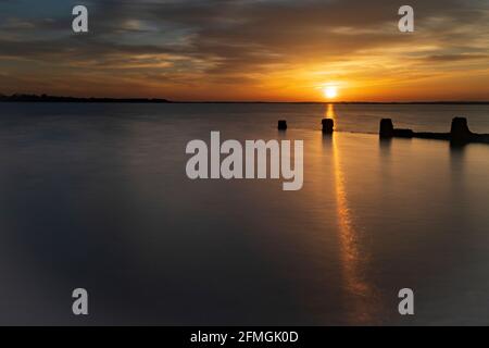 Coucher de soleil à Brightlingsea sur la côte d'Essex du Royaume-Uni.prise d'une longue exposition, pendant le week-end de Pâques. Banque D'Images