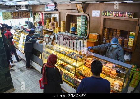 Srinagar, Inde. 09e mai 2021. Les résidents font leurs courses dans une boulangerie avant le festival musulman Eid al-Fitr lors d'un confinement imposé par les autorités suite à l'augmentation des cas de coronavirus à Srinagar. Alors que le mortel Covid-19 continue de menacer la vallée, les autorités ont prolongé dimanche le confinement actuel du COVID-19 devant le festival musulman Eid al-Fitr. Crédit : SOPA Images Limited/Alamy Live News Banque D'Images